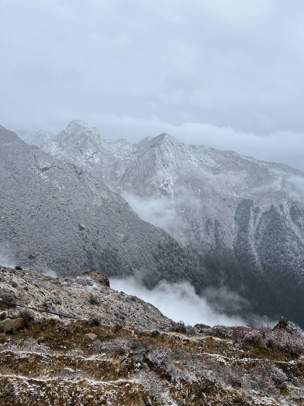 a mountain range covered in snow and clouds