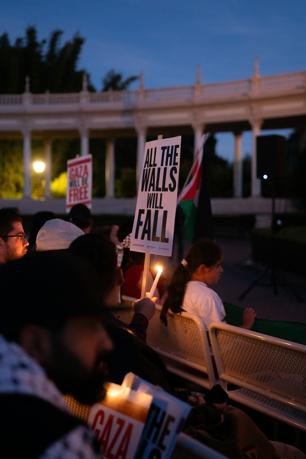 a group of people holding candles and signs