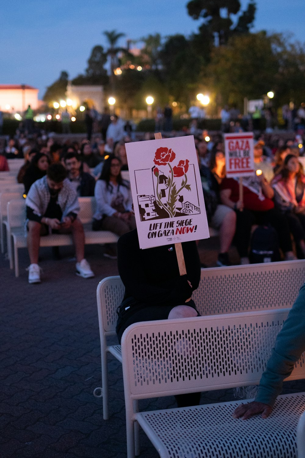 a person sitting on a bench holding a sign