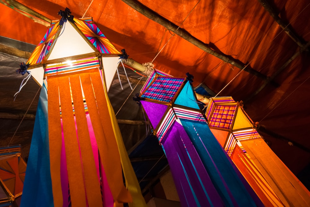 a group of colorful kites hanging from a ceiling