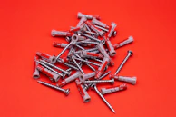 A collection of colorful coated screws and anchors spread out on a white background.