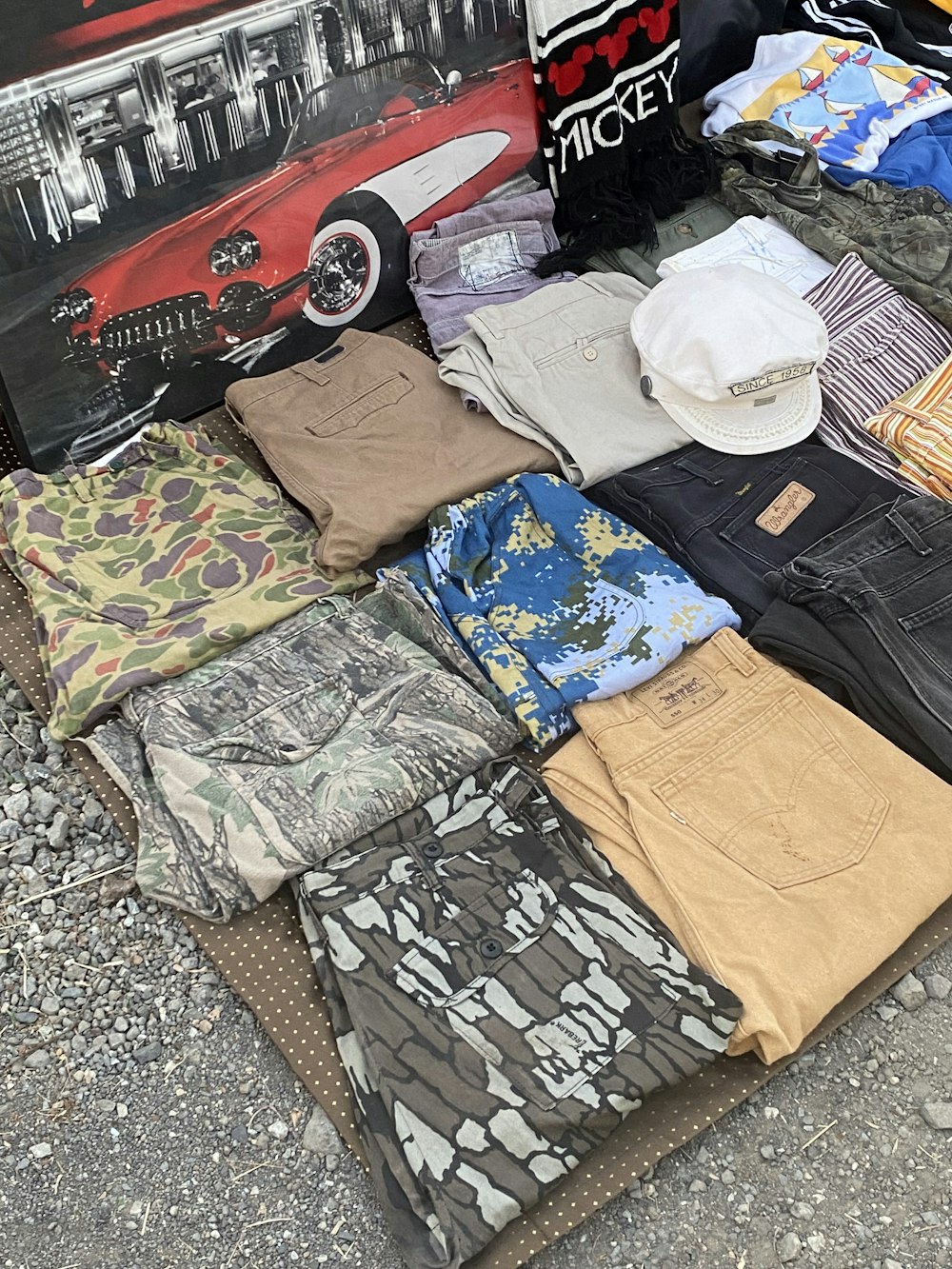 a pile of clothes sitting on top of a sidewalk