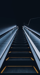 an escalator with yellow lights going down it