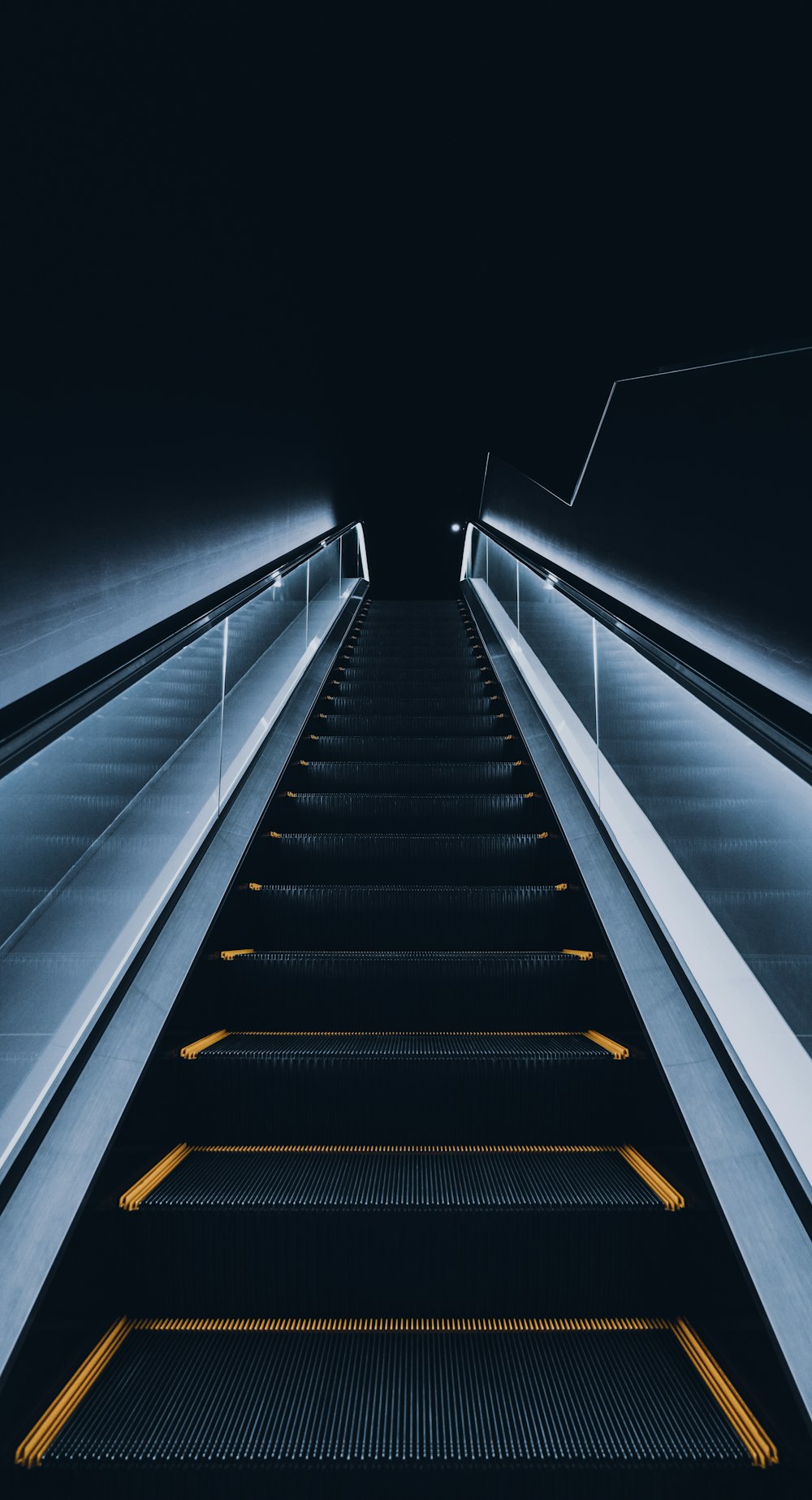 an escalator with yellow lights going down it