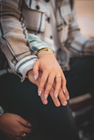 Close-up of hands gently clasped during a heartfelt conversation.
