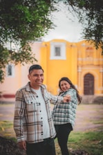 A friendly real estate agent shaking hands with a happy couple outside a charming Jacksonville home.