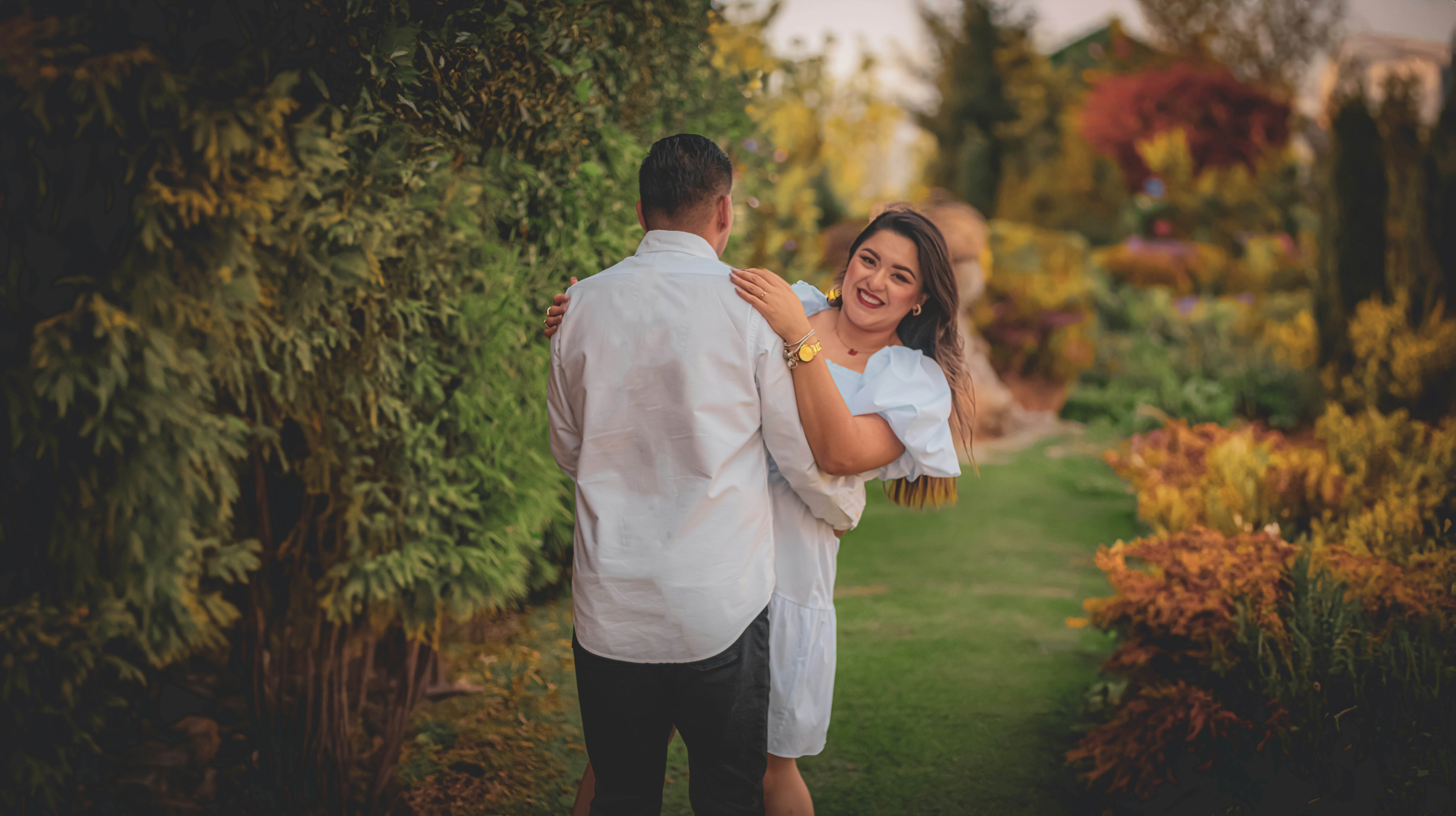 a man holding a woman in his arms in a garden