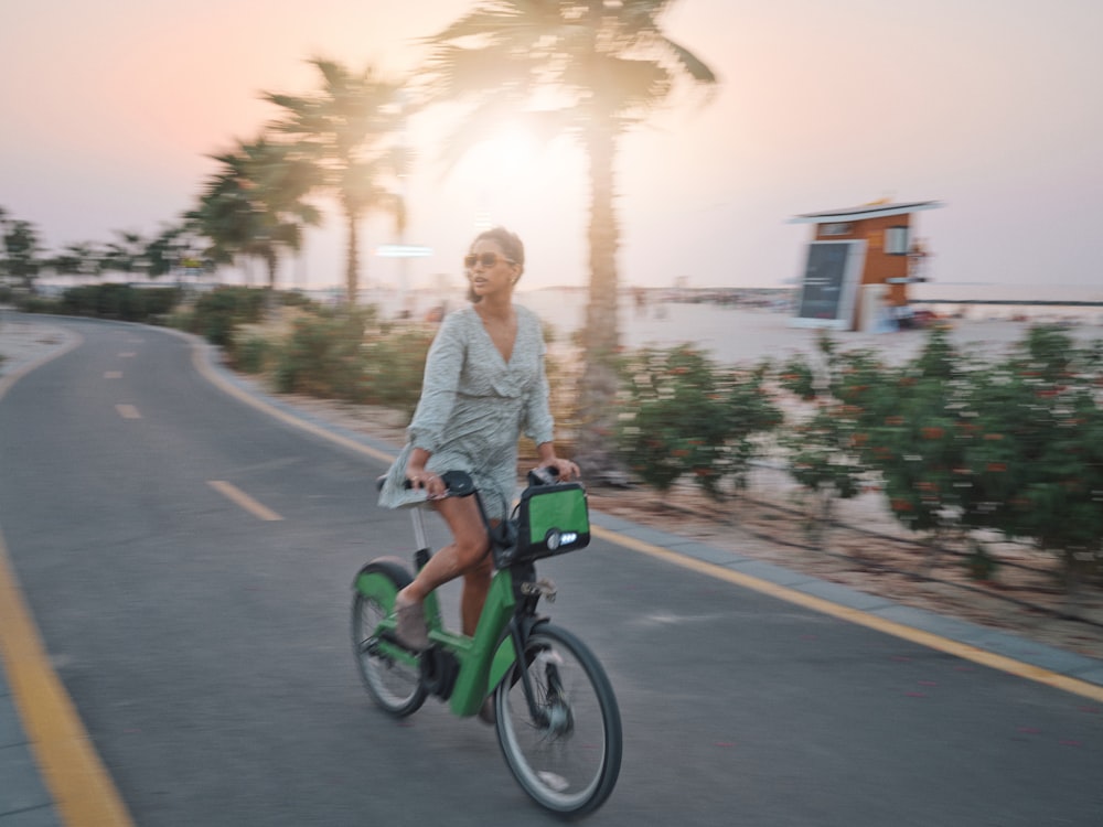 a woman riding a bike down a street