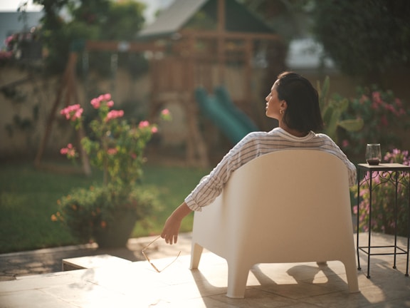 A peaceful backyard garden with blooming flowers and a comfortable chair, perfect for afternoon reflection.