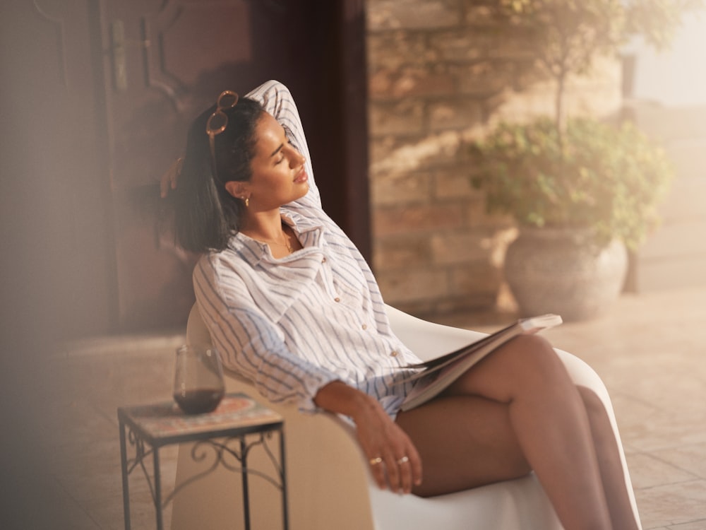 a woman sitting on top of a white bench