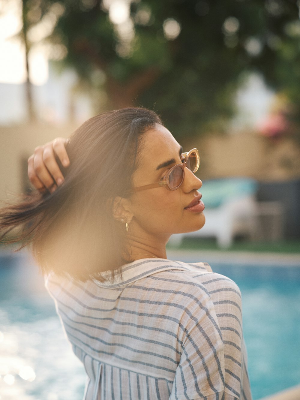 a woman standing next to a swimming pool