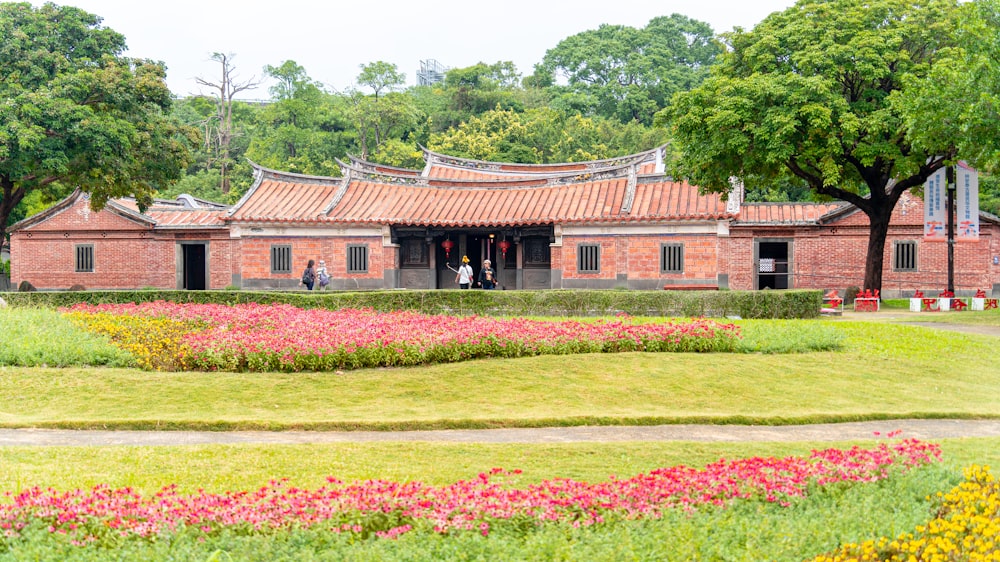 a red brick building surrounded by flowers and trees