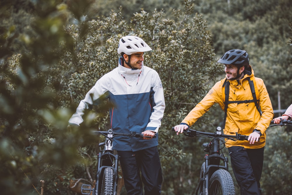 three people standing next to each other with their bikes