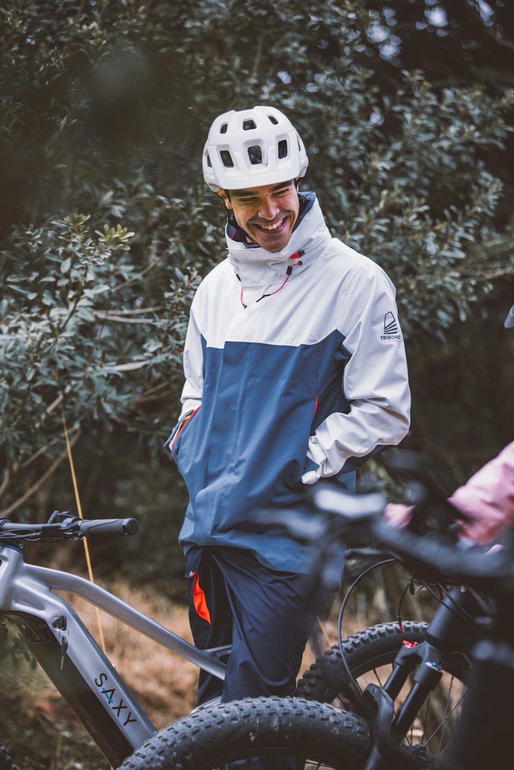 a man standing next to his bike in the woods