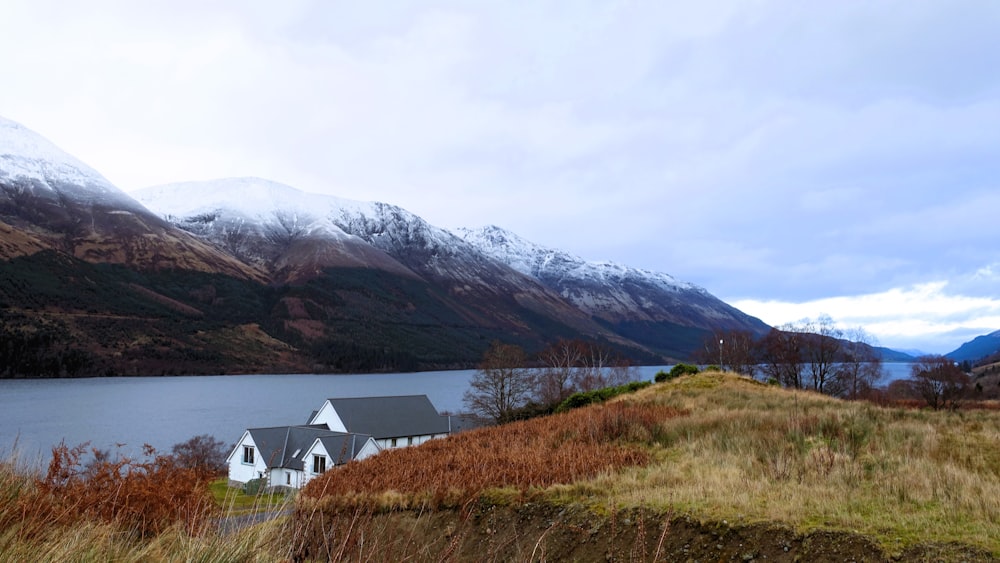 a house sitting on top of a hill next to a lake