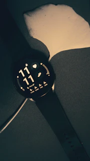 a watch is sitting on a black surface