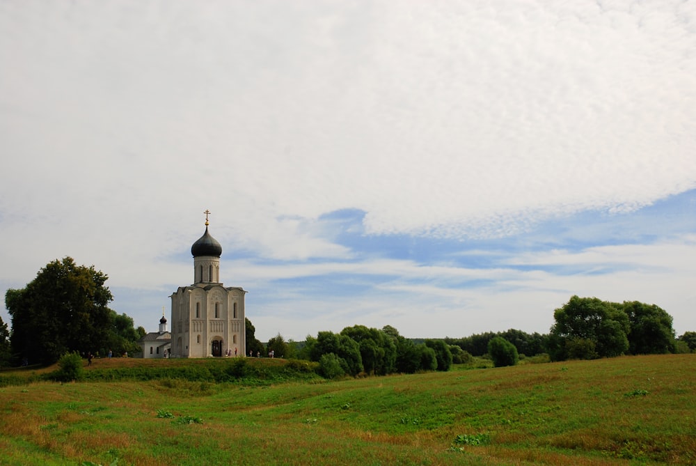 une église dans un champ avec un fond de ciel