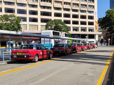 A row of clean and modern taxis parked in front of a shopping mall.