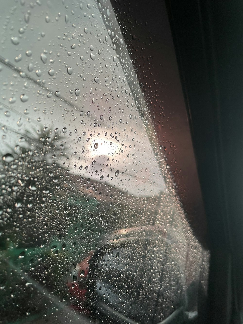 uma vista de um carro através de uma janela coberta de chuva