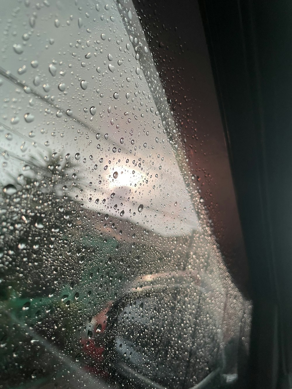 a view of a car through a rain covered window