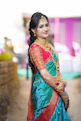 A joyful model showcasing a bold American diamond necklace set paired with vibrant Bollywood-style clothing.