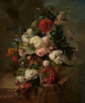A lush, ornate arrangement of various flowers displayed against a dark, muted background. The bouquet features a mix of white, red, pink, and yellow blossoms interwoven with rich green foliage, creating a sense of depth and opulence.