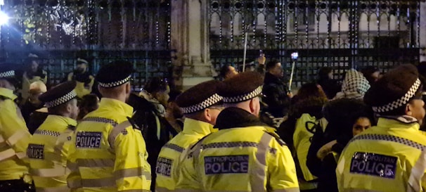 Uniformed security personnel managing crowd control at a lively outdoor event.