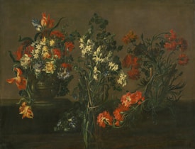 An arrangement of diverse flowers with vibrant red, white, and orange petals set in a dark, earthy background. The flowers are placed in an ornate vase and exhibit intricate details of leaves and stems intertwined. The composition creates a sense of depth and texture, highlighting the delicate nature of each bloom.
