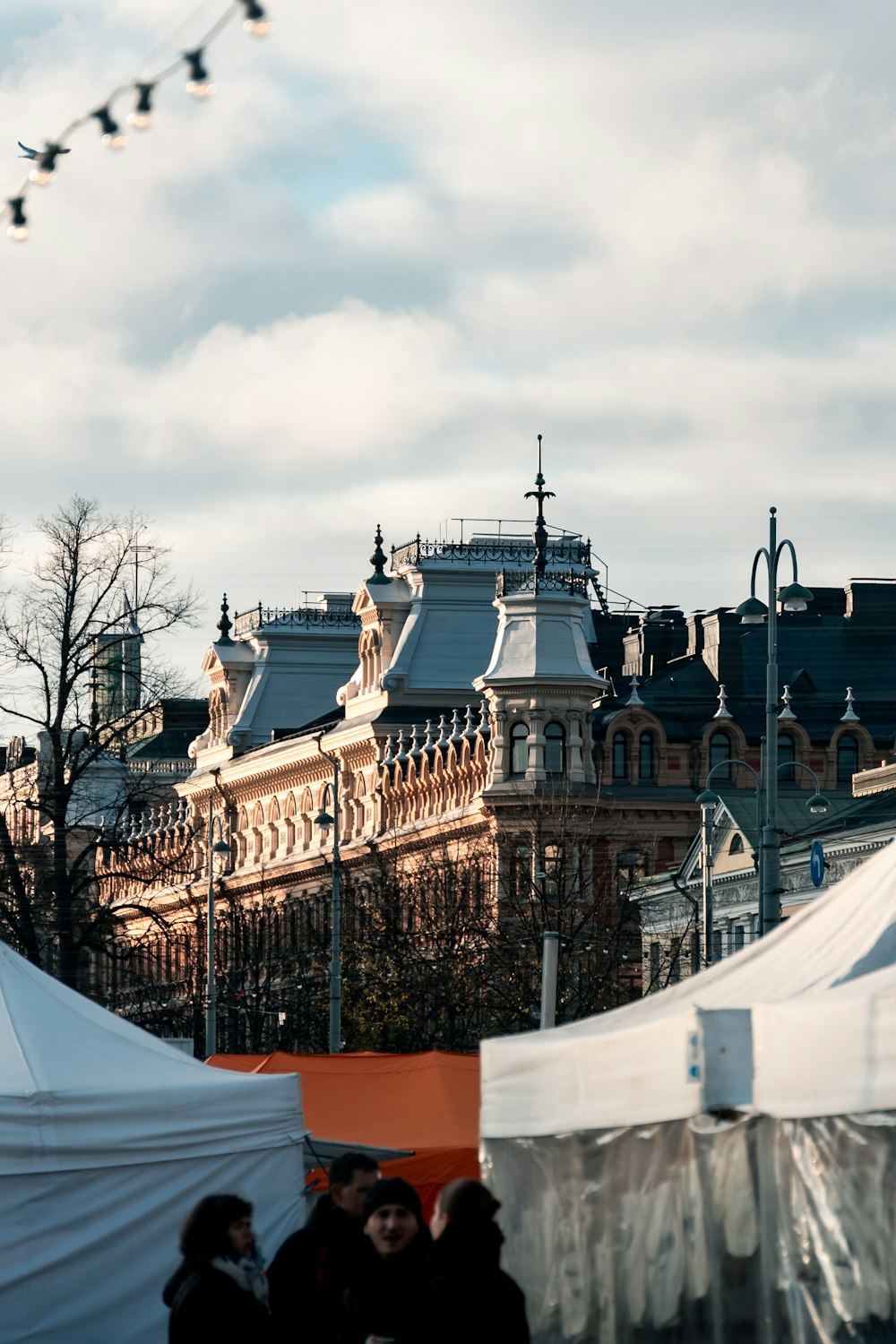 a group of people standing around tents in front of a building