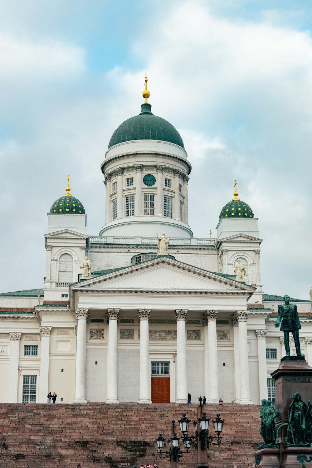 a large white building with a green dome