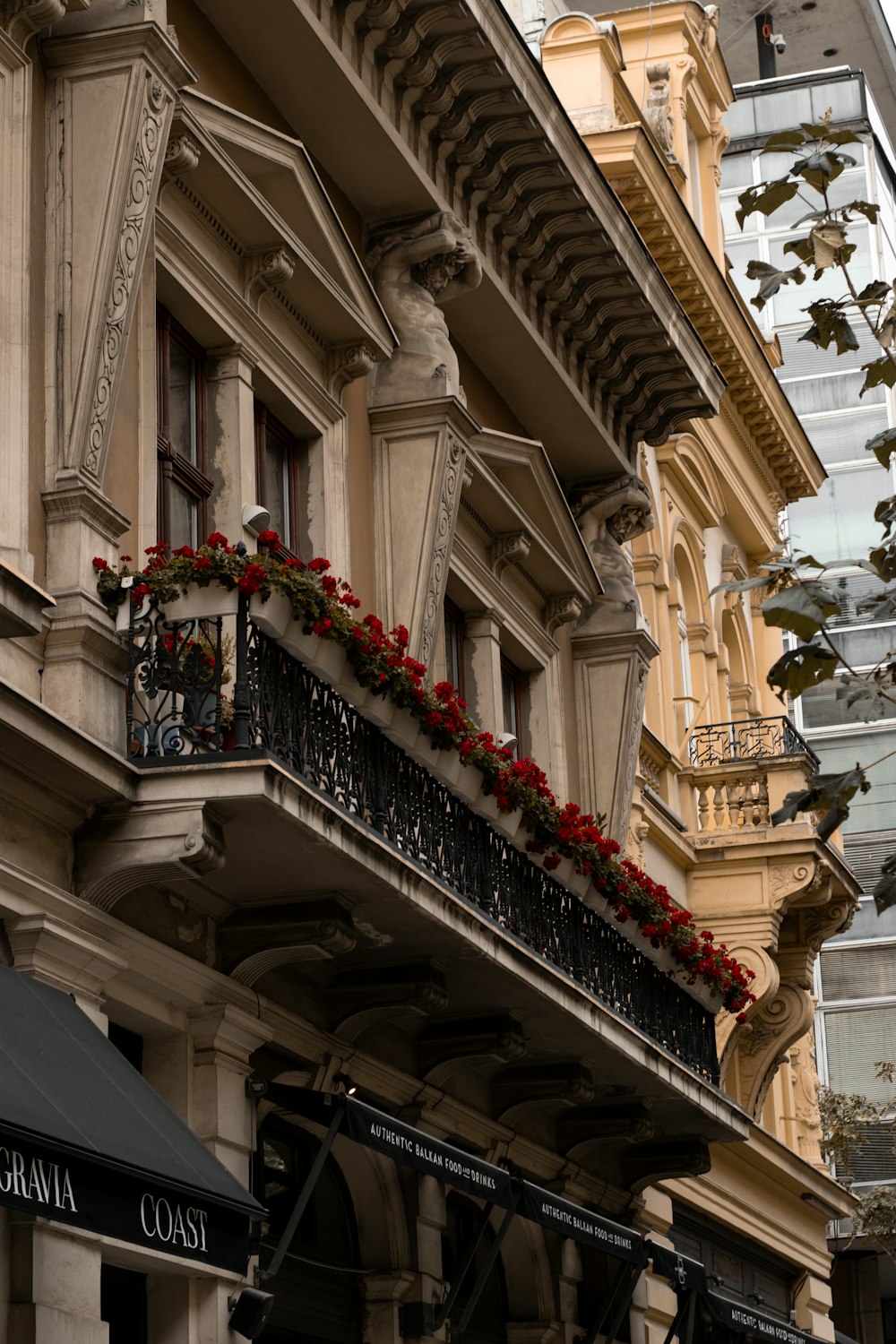 a building with a balcony with flowers on it