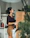 A smiling woman standing beside a sleek, modern room divider in a bright living room.