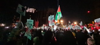 A striking nighttime scene of supporters holding illuminated banners stating firm patriotic slogans.