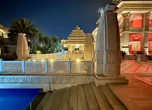 a night view of a building with a pool in front of it