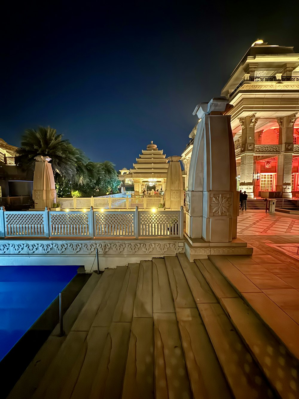 a night view of a building with a pool in front of it