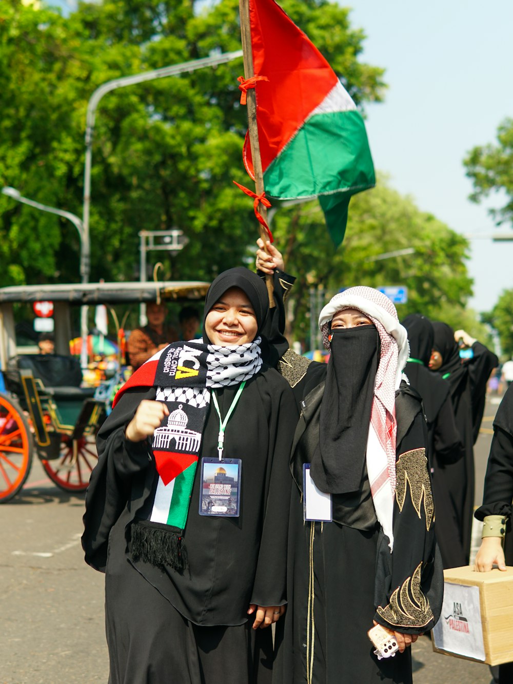 a group of women walking down a street holding flags