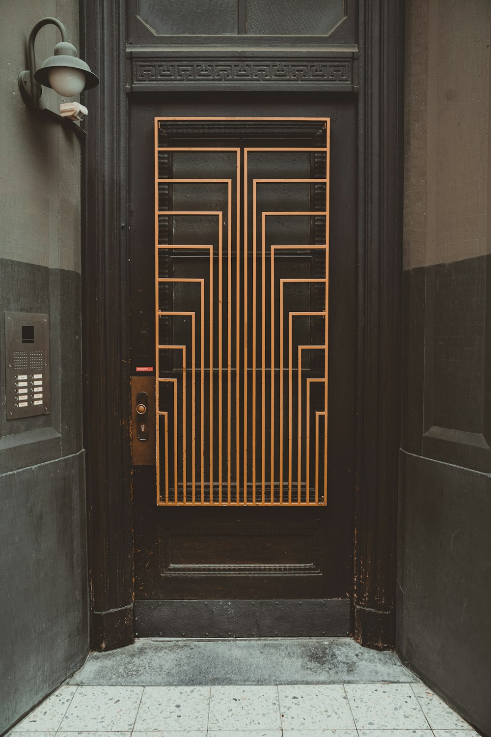 a black door with a gold gate on it