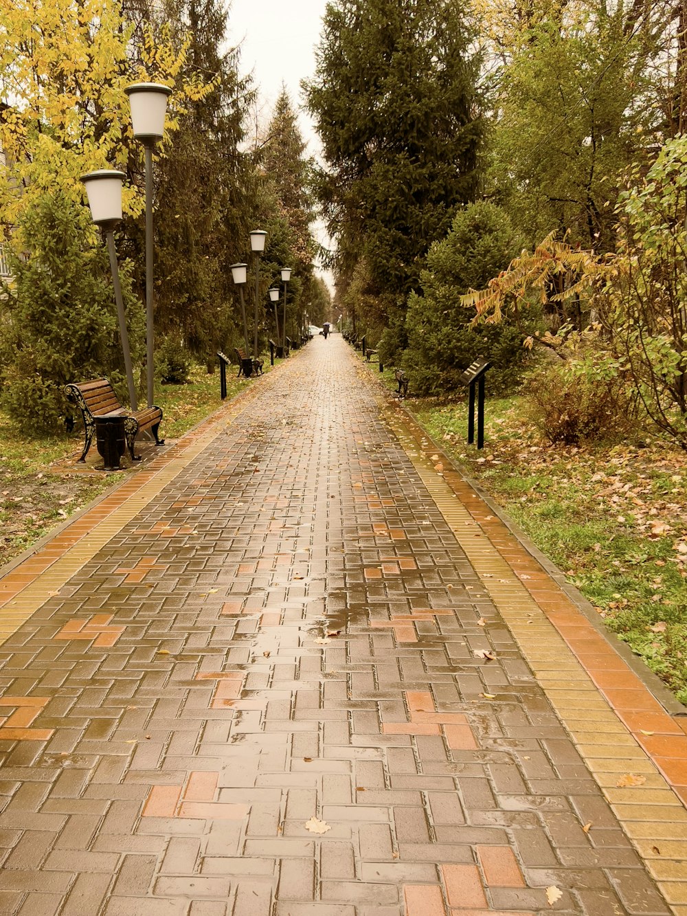 a brick road with a bench on the side of it