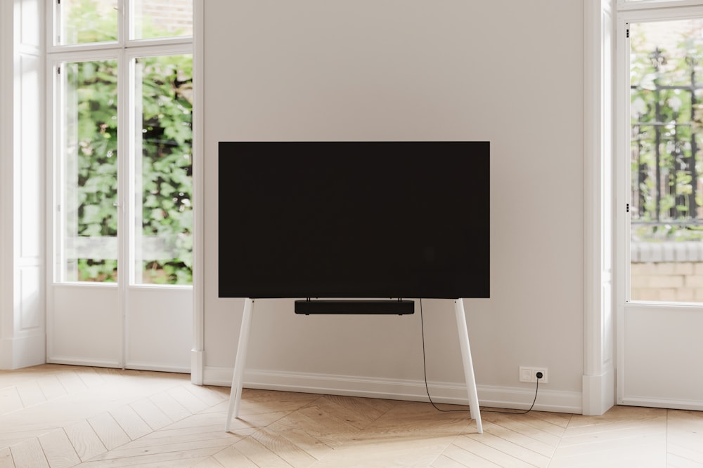 a flat screen tv sitting on top of a wooden stand