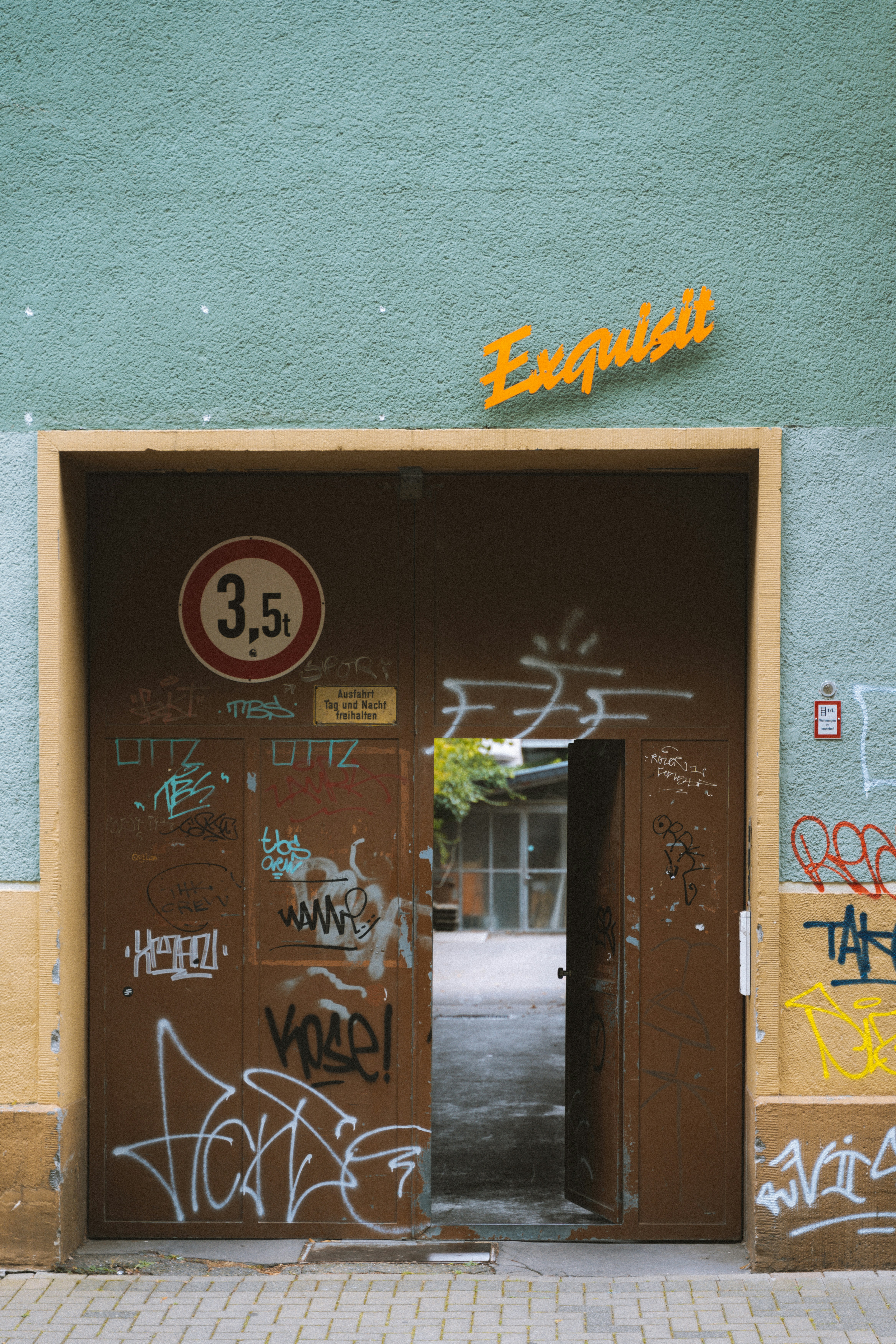 an open door with graffiti on the side of a building