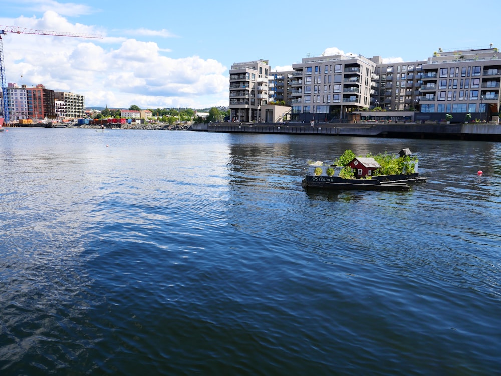 a small boat floating down a river next to tall buildings