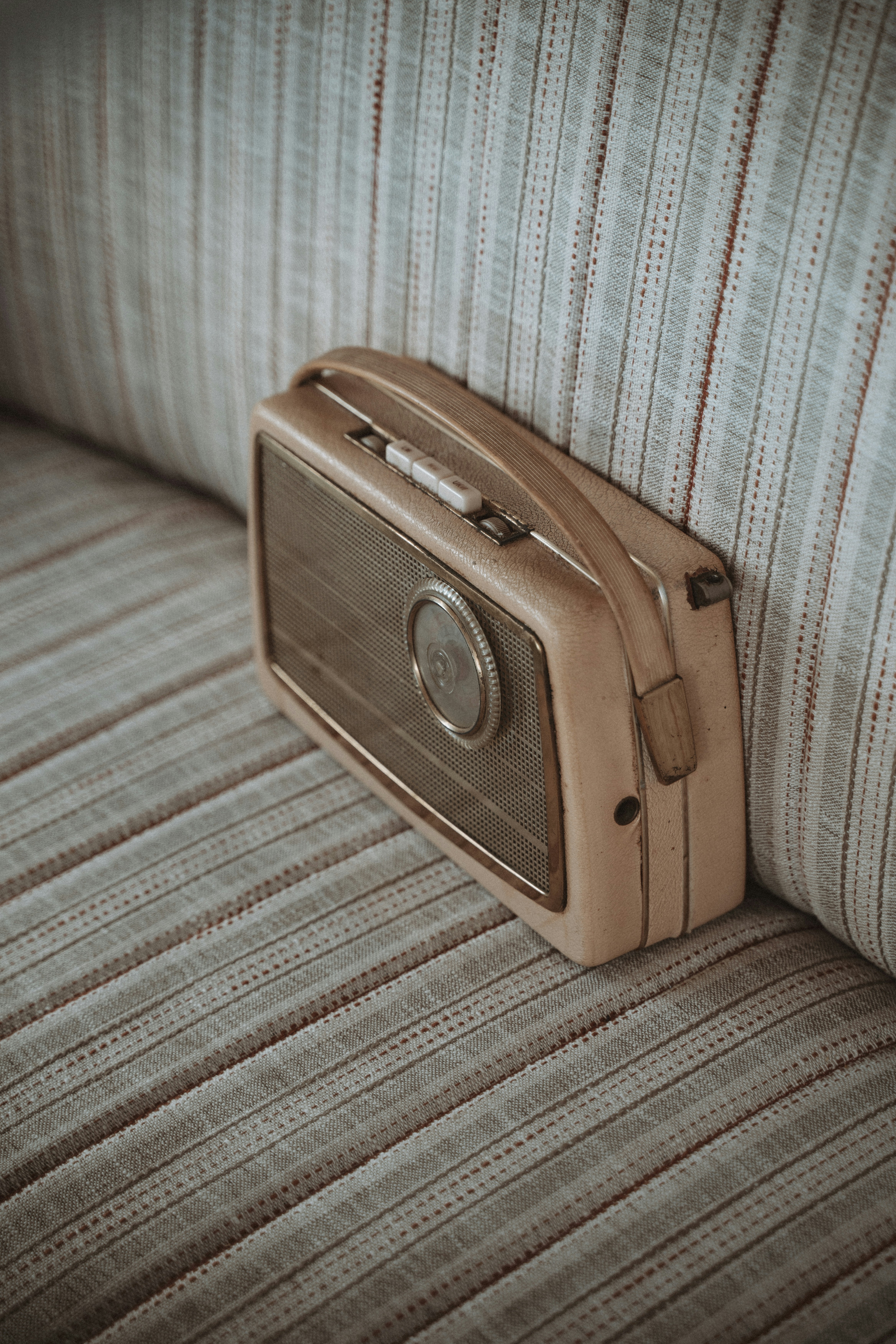 a radio sitting on top of a couch next to a pillow