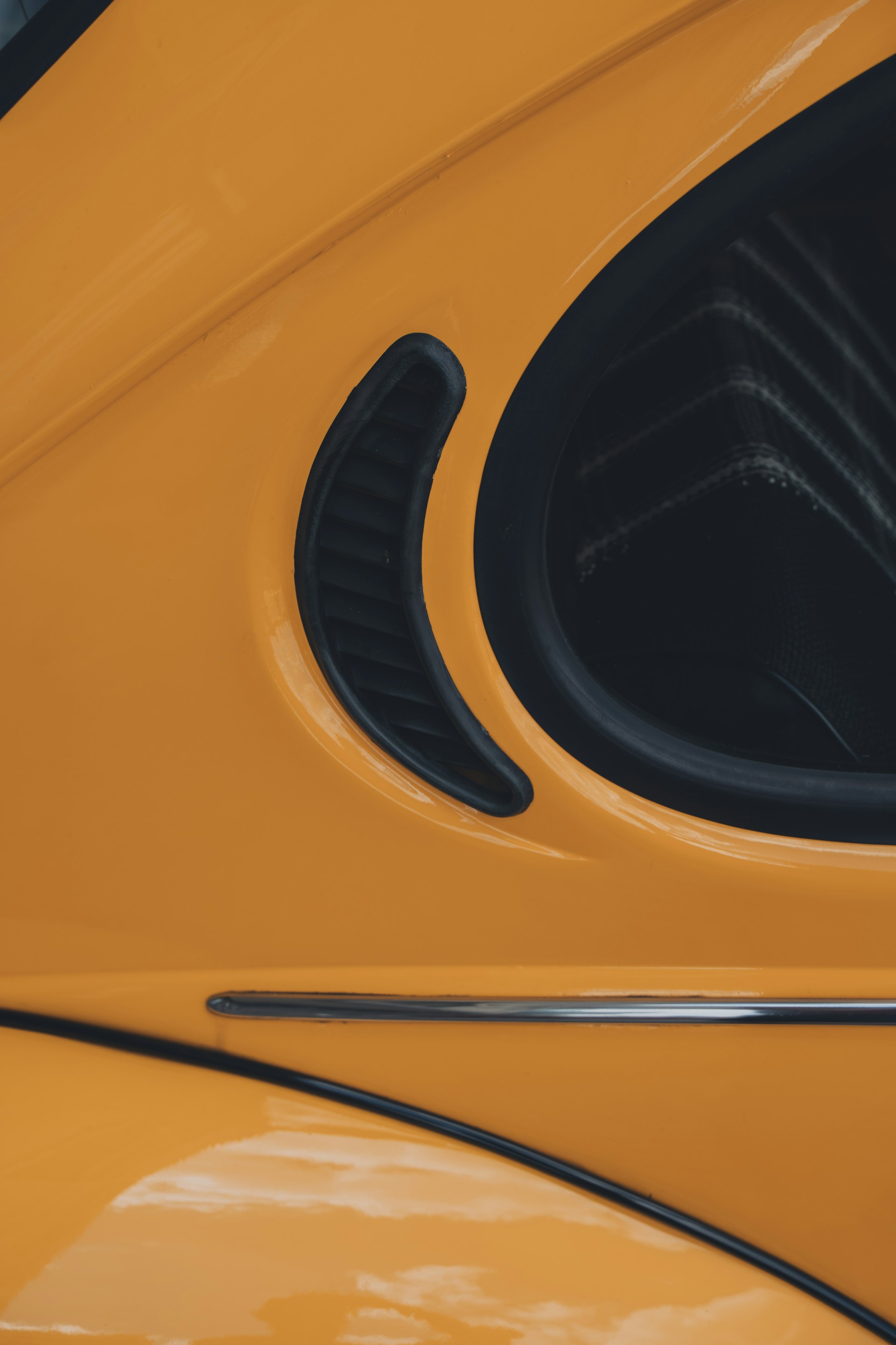 a close up of a yellow car door with black trim