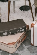 A variety of suitcase styles displayed on a wooden floor, showcasing different colors and textures.