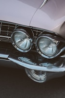 Close-up of vintage car headlights and bumpers ready for sale.