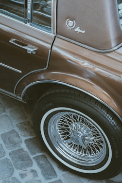 a brown car parked on a cobblestone street