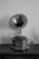 A vintage gramophone with an ornate horn and a decorative base, placed on a wooden surface. The gramophone has intricate engravings and a winding handle, evoking a sense of nostalgia.