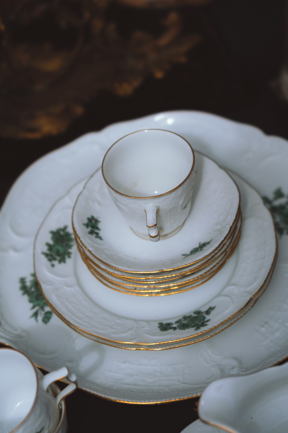 a stack of white and gold china plates