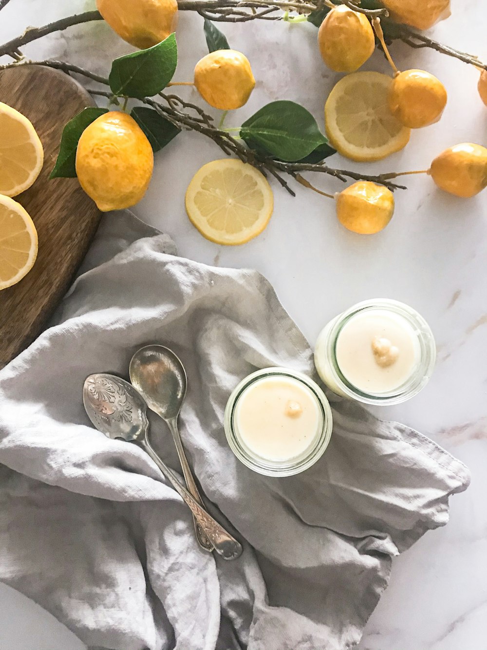 a table topped with lemons and two glasses of milk
