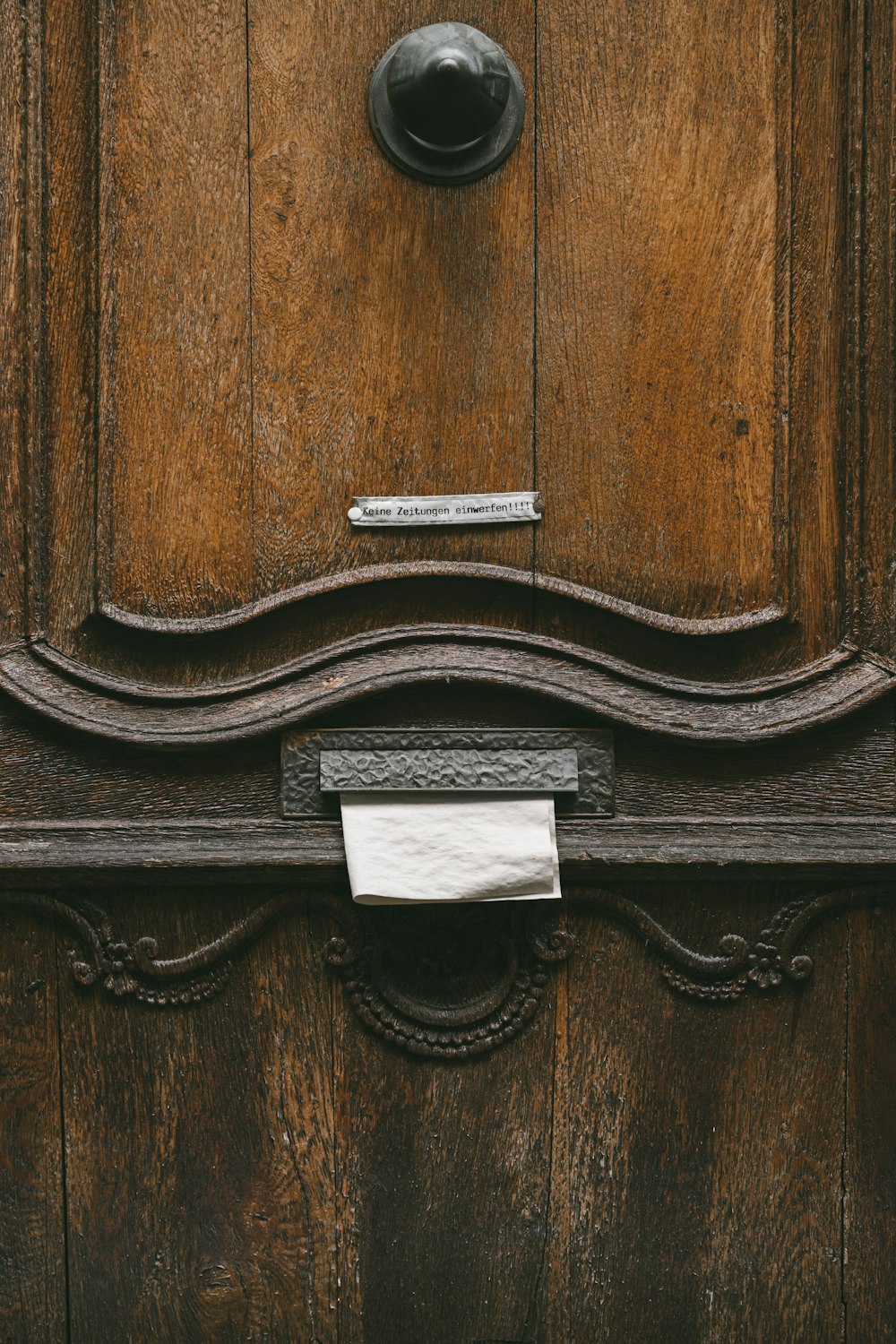 Eine Nahaufnahme einer Holztür mit einem Schild darauf